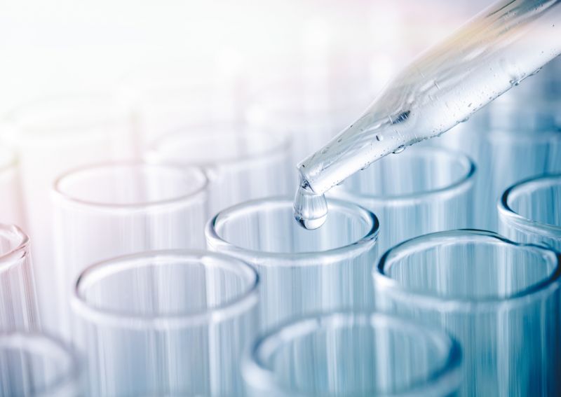 Foto; Pipette entnimmt Flüssigkeit aus einem Reagenzglas, Nahaufnahme