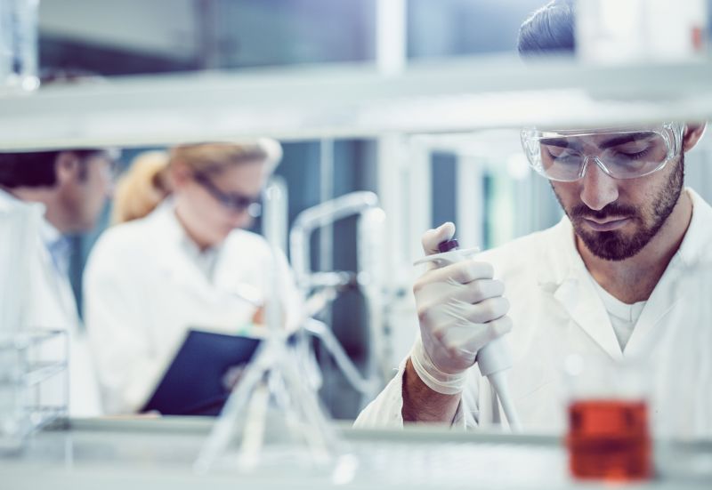 Photo; laboratory technician with a pipette in a laboratory