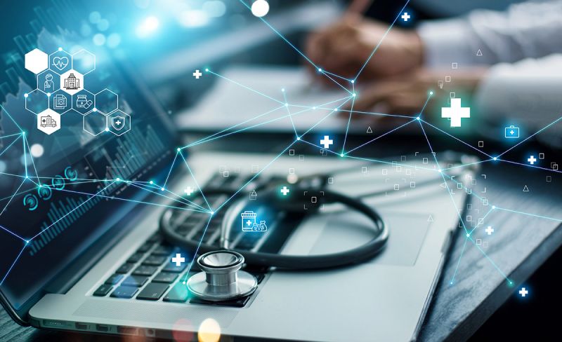 Symbolic image; laptop, a stetoscope lies on the keyboard; in the foreground a floating network of lines and icons
