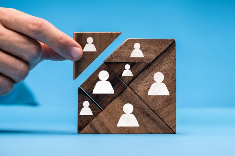 Foto; Holzpuzzle mit symbolischen Icons wird zusammengesetzt